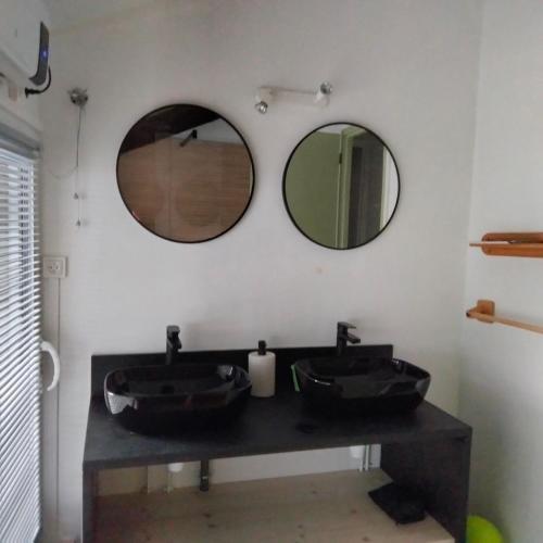 La salle de bains est pourvue de 2 lavabos et de 2 miroirs sur le mur. dans l'établissement Corps de ferme rénové, à Latour-de-Carol