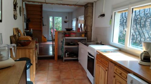 une cuisine avec un évier et une cuisinière four supérieur dans l'établissement Corps de ferme rénové, à Latour-de-Carol