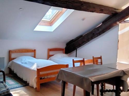une chambre avec deux lits et une table et une fenêtre dans l'établissement Corps de ferme rénové, à Latour-de-Carol