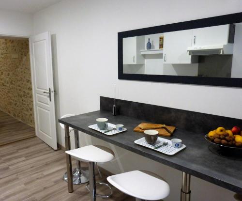 une cuisine avec une table avec deux tabourets et une table avec des fruits dans l'établissement Le Quarante, à Périgueux