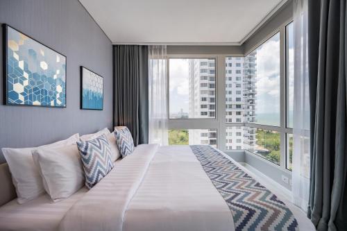 a large bed in a room with a large window at 3BR Seaview - Veranda Pattaya - Luxe in Na Jomtien