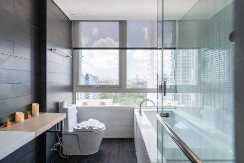a bathroom with a tub and a toilet and a window at 3BR Seaview - Veranda Pattaya - Luxe in Na Jomtien