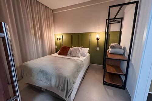 a bedroom with a large bed and a mirror at Apartamentos Elegance 413 in Bombinhas