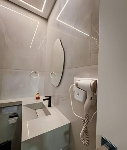 a bathroom with a hair dryer and a mirror at Apartamentos Elegance 413 in Bombinhas