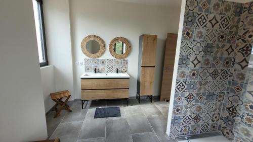 une salle de bain avec un lavabo et des miroirs au mur dans l'établissement Villa paisible en Provence, à Orange