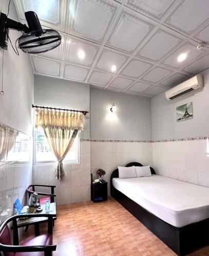a bedroom with a white bed and a window at Nam Đô Hotel Cần Thơ Downtown in Can Tho