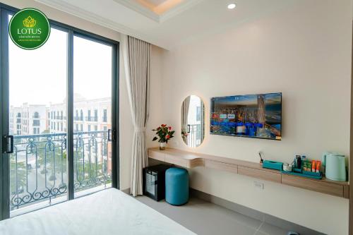 a hotel room with a balcony with a large window at Lotus Sầm Sơn Hotel in Sầm Sơn
