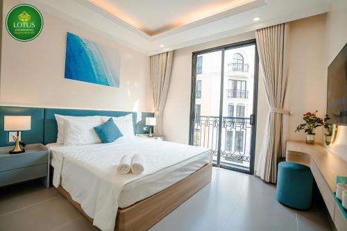 a bedroom with a bed and a large window at Lotus Sầm Sơn Hotel in Sầm Sơn