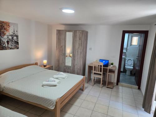 ein Schlafzimmer mit einem Bett und ein Badezimmer mit einer Toilette in der Unterkunft Apartmani Vitic in Bar
