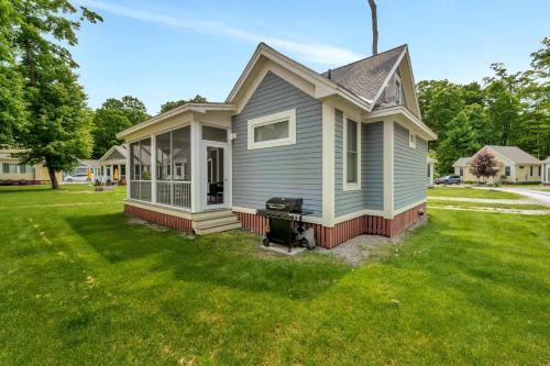 a small house with a grill in a yard at The Tamarack - 11 Hollow in Cherry Valley