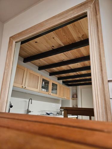 a mirror in a kitchen with a wooden ceiling at Le Loft de Genas - la Bastide, le Chalet, le Loft, le Mas, la Paillote in Genas