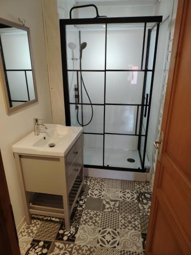 une salle de bain avec un lavabo et une douche dans l'établissement Au sable fin, à Grand-Fort-Philippe