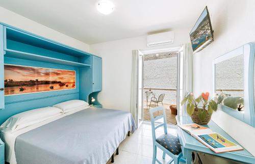 a blue bedroom with a bed and a desk at Hotel Villa D'Orta in Ischia
