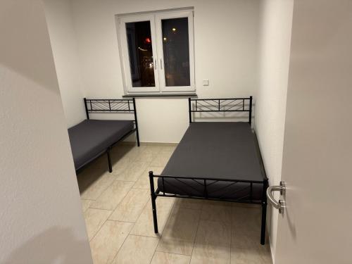 two beds in a small room with a window at 3 Zimmer Apartment in Wiesbaden in Wiesbaden