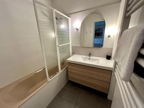 une salle de bain avec un lavabo, une baignoire et un miroir dans l'établissement Tony Garnier 2 bedrooms - balcony - parking, à Lyon