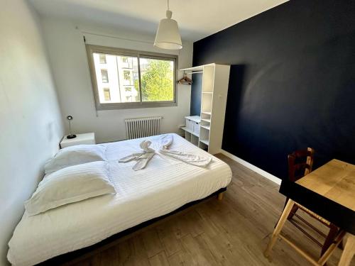 une chambre avec un lit, un bureau et une fenêtre dans l'établissement Tony Garnier 2 bedrooms - balcony - parking, à Lyon