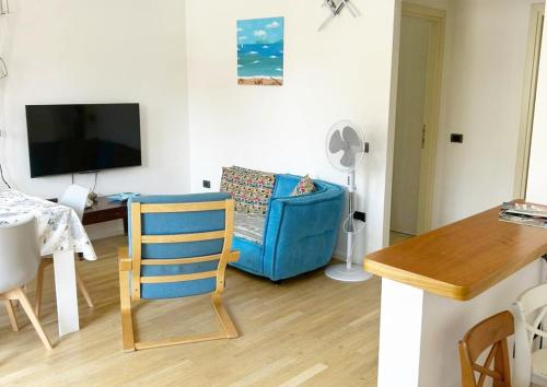 a living room with a blue chair and a couch at Casa La Marina a Marina di Cecina by Zoom In Earth in Marina di Cecina