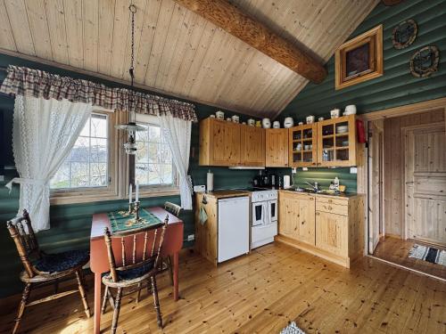 a kitchen with green walls and a table and chairs at Cottage Yard - cozy Cabin in Geilo