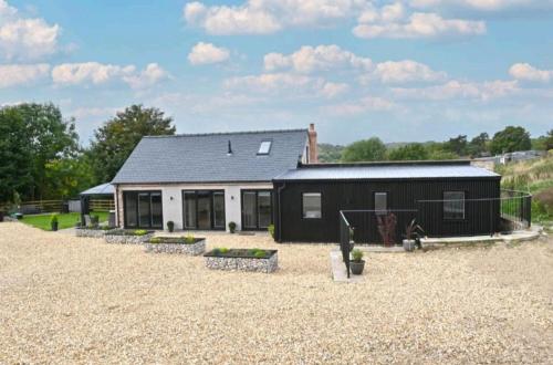 a black and white house with a gravel yard at Bage Mine Barn in Wirksworth
