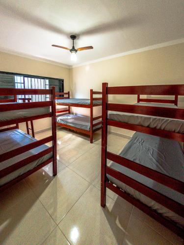 a room with three bunk beds and a ceiling at Pacheco Festas & Eventos in Barretos