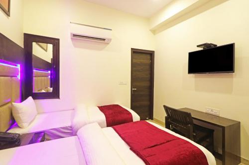 a hotel room with two beds and a flat screen tv at Hotel Stay Villa - Free Airport Drop in New Delhi