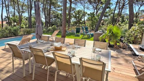 une table à manger et des chaises sur une terrasse avec une piscine dans l'établissement Villa Casa di Mare, à Sainte-Maxime