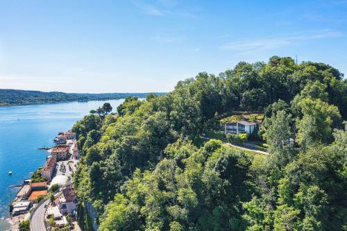 an aerial view of a house on a hill next to the water at Stylish villa & spectacular views! - Villa La Rocca in Arona