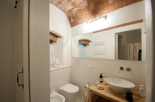 a bathroom with a sink and a toilet and a mirror at Vieniviaconmehome in Casale Marittimo
