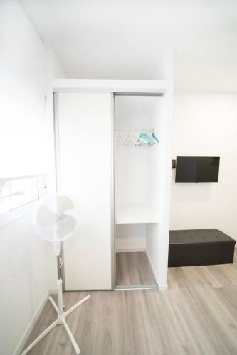 a white living room with a table and a tv at En Madrid, amplio, especial grupos o familias in Leganés