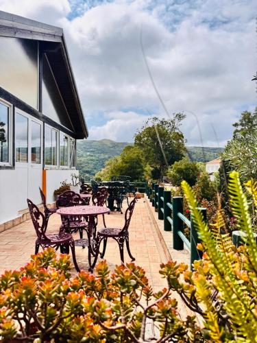 a patio with a table and chairs and flowers at Bica Boa in Monchique