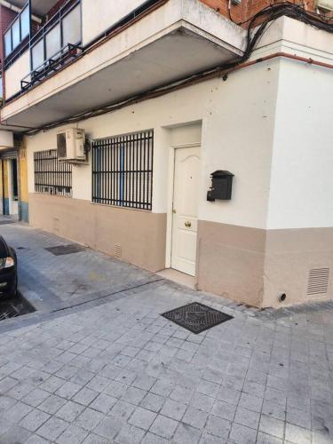 a white building with a door on the side of it at En Madrid, amplio, especial grupos o familias in Leganés