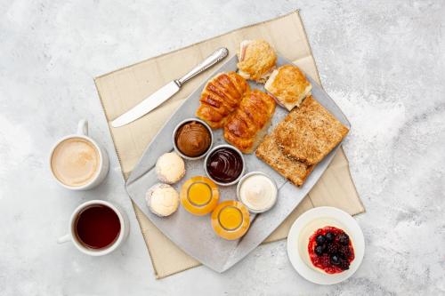 - un plateau de viennoiseries et d'autres aliments pour le petit-déjeuner sur une table dans l'établissement L'Opale, appartement neuf by Primo, à Cucq