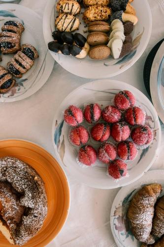 a table with plates of pastries and plates of desserts at Hotel Belvedere in Sperlonga