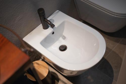 a white sink in a bathroom next to a toilet at Il rifugio illuminato in Semproniano