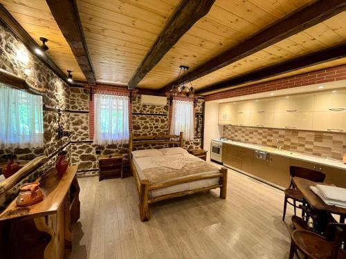 a bedroom with a bed in a room with wooden ceilings at Vechia Villa Mitllari in Tushemisht