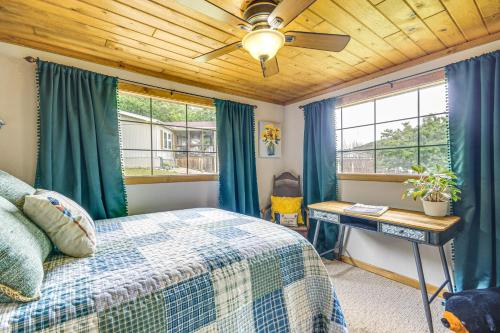 a bedroom with a bed and a desk and windows at Hike, Swim and Fish Lakefront Cabin in Roach! in Roach