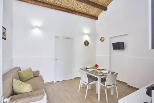 a living room with a table and a couch at Casale Sammartano Apartments in Ummari