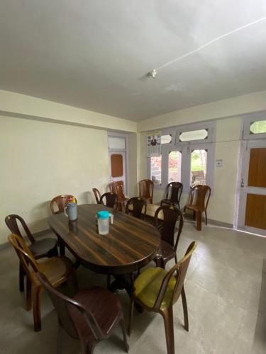 a dining room with a wooden table and chairs at Shanti Homestay in Kalpa