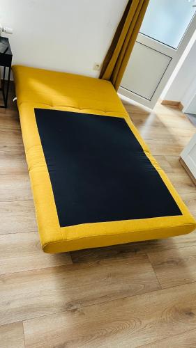a yellow and black rug on a wooden floor at SalzinnesChezSoi 1 in Namur