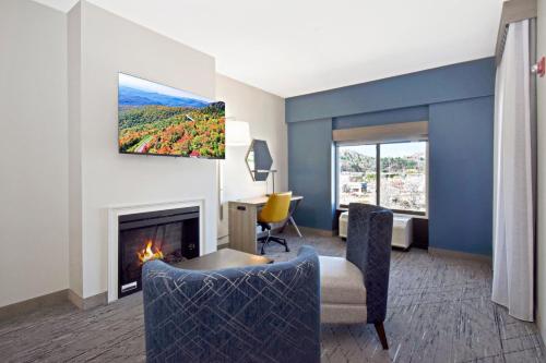 a living room with a fireplace and a tv on the wall at Holiday Inn Express Boone by IHG in Boone