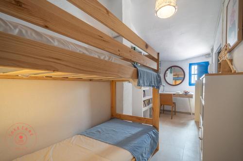 ein Schlafzimmer mit zwei Etagenbetten und einem Schreibtisch in der Unterkunft Authentic fisher house in Pedregalejo - TCM in Málaga