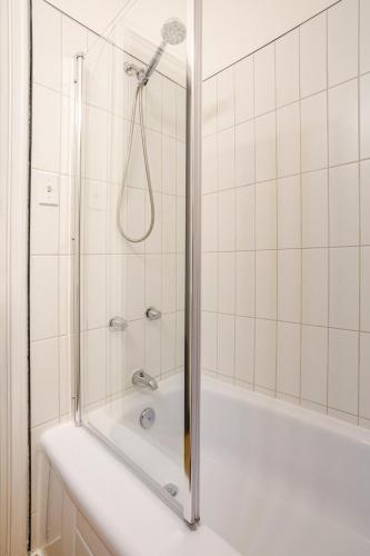 a white bathroom with a shower and a tub at Haute mer in Quebec City