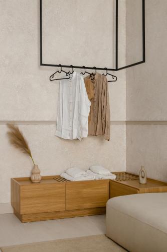 a bedroom with a bed and a dresser with a clothes rack at Luxury Suites by Lato in Agios Nikolaos