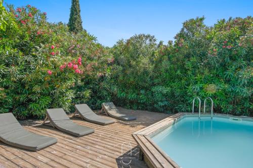 un patio avec des chaises, une piscine et des arbres dans l'établissement Le Mas de Lila , vieux mas en pierres avec piscine, à Hyères