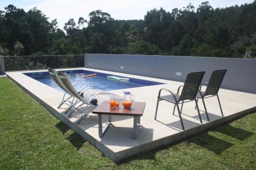 a patio with chairs and a table next to a swimming pool at Calçada Velha in Viana do Castelo