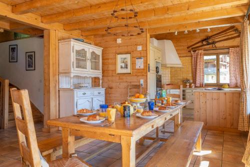 une cuisine avec une grande table en bois et de la nourriture. dans l'établissement Chalet Mélèze, aux Gets