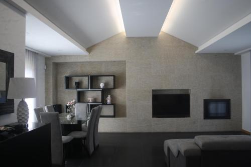 a living room with a dining table and a television at Calçada Velha in Viana do Castelo