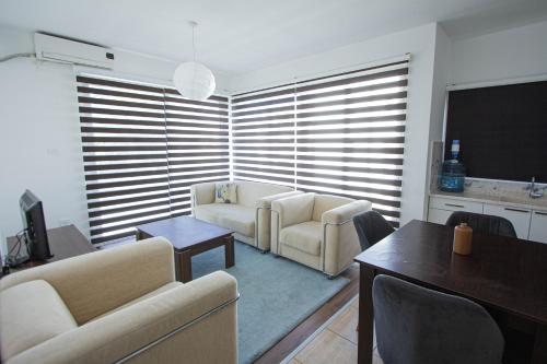 a living room with two chairs and a table and a couch at RiX Sunny Apartments in Kérynia