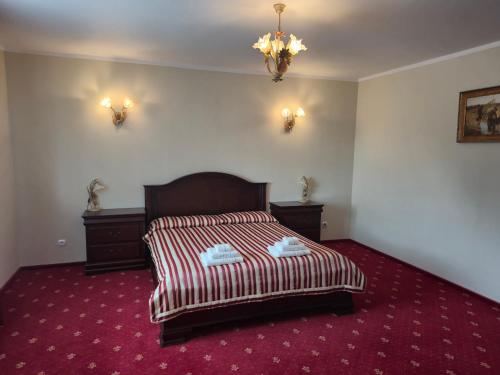 a bedroom with a bed with a red carpet at Villa Murano in Sajzy
