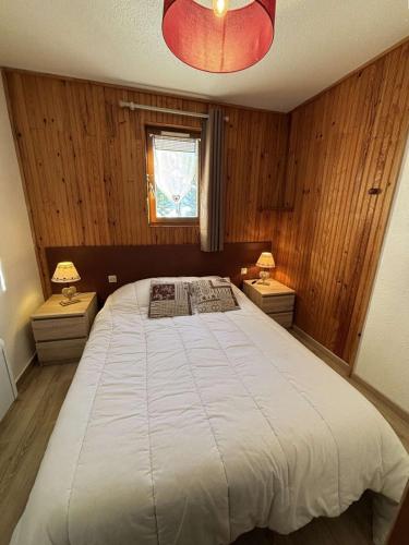 une chambre avec un grand lit avec deux tables de nuit dans l'établissement Yéti 6 n° 8 : appartement rénové au Petit Chatel, à Châtel